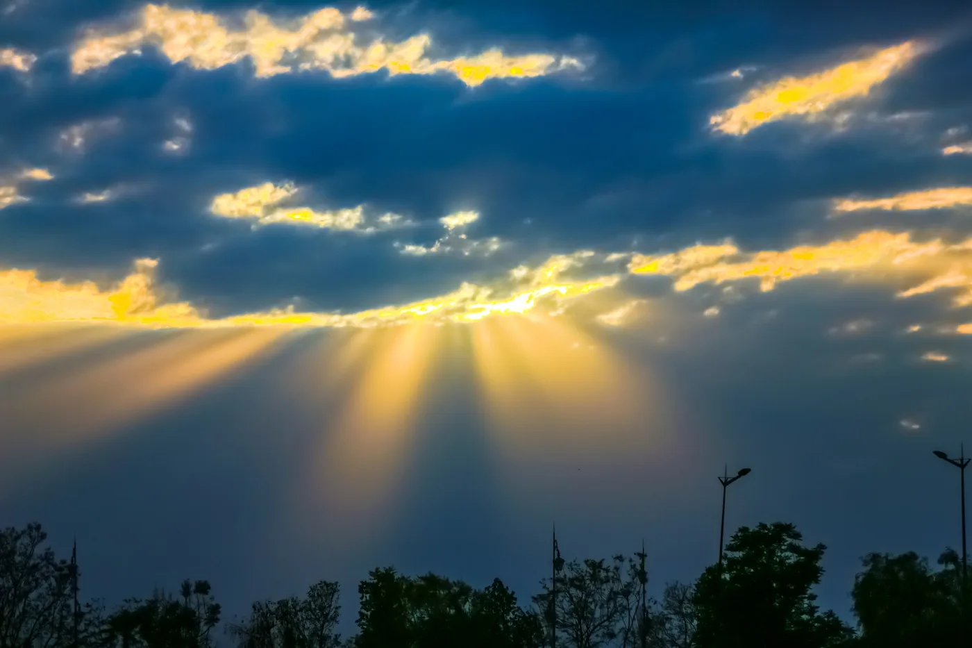Rayons, Rayons de soleil à travers les nuages au-dessus d'arbres