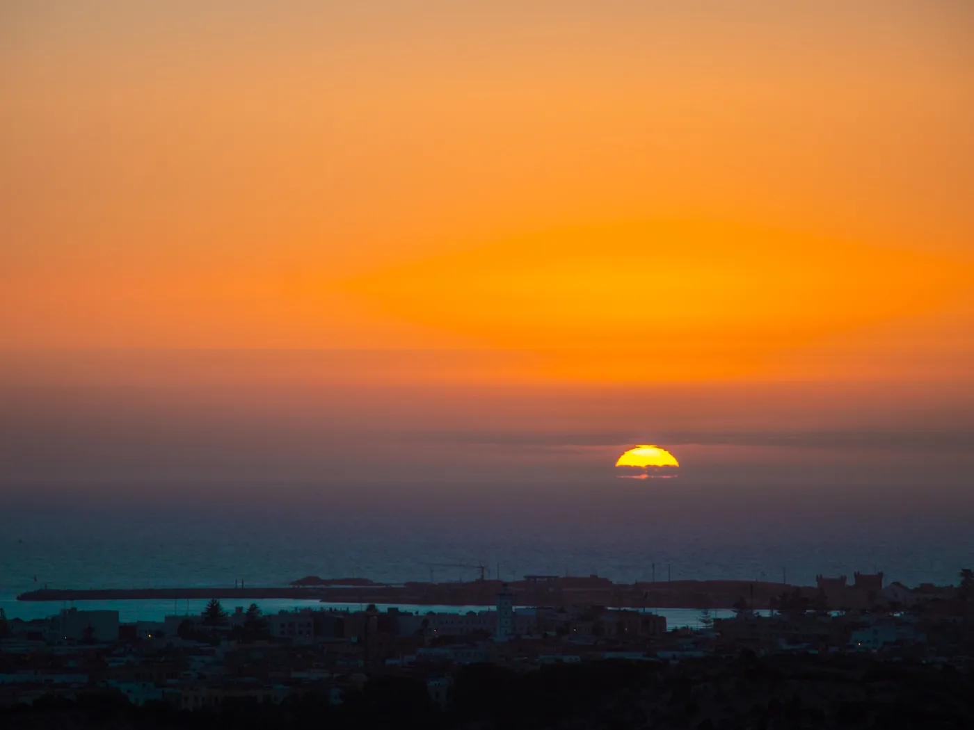Soleil d'Essaouira, Soleil couchant dans un ciel orange au-dessus du port d'Essaouira