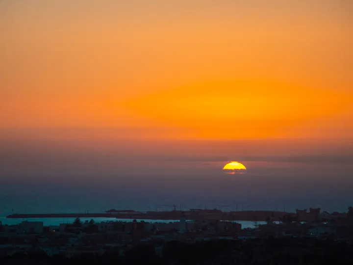 Soleil d'Essaouira, Soleil couchant dans un ciel orange au-dessus du port d'Essaouira
