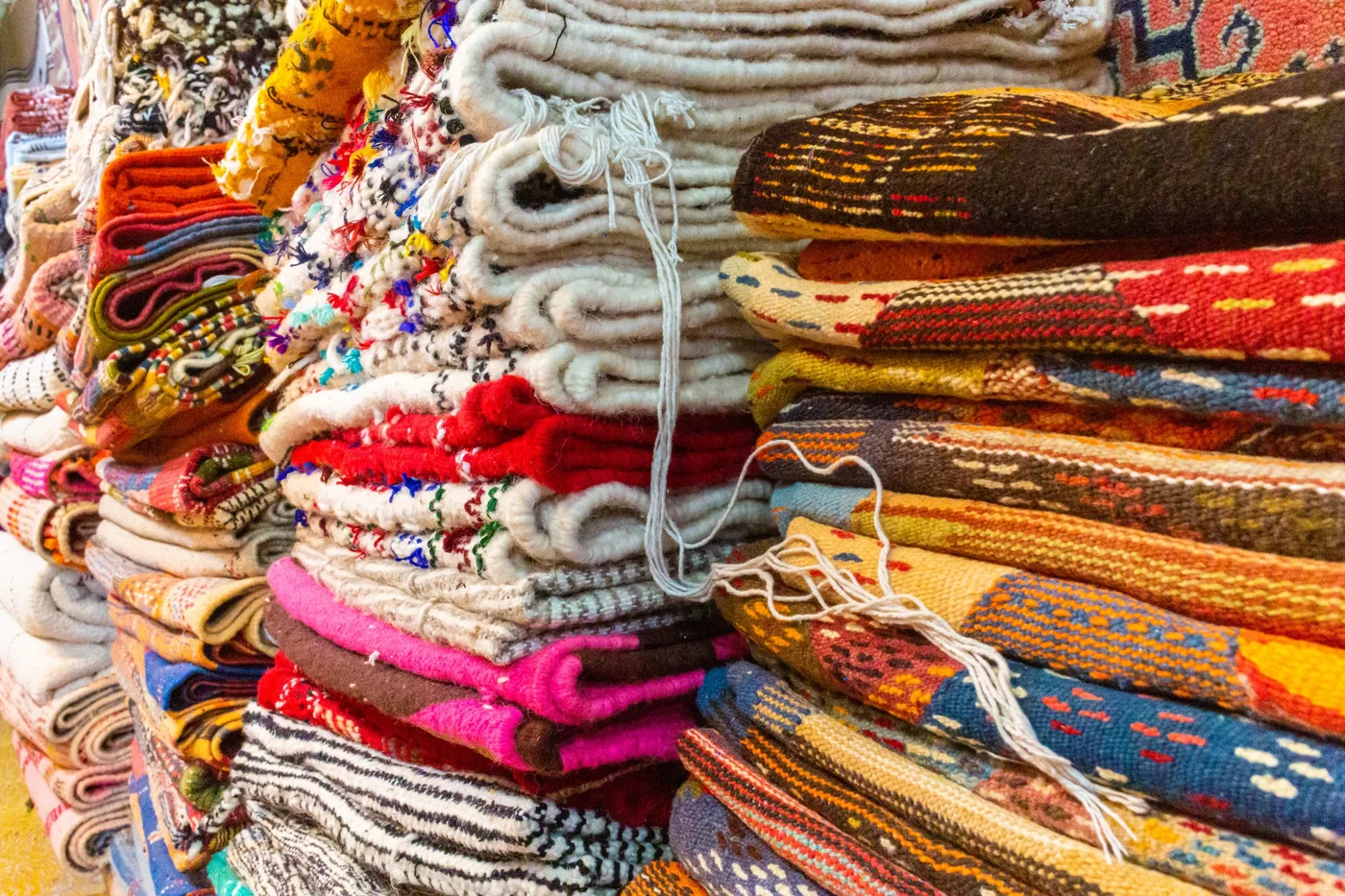 Laines, Pile de couvertures et tissages colorés à motifs