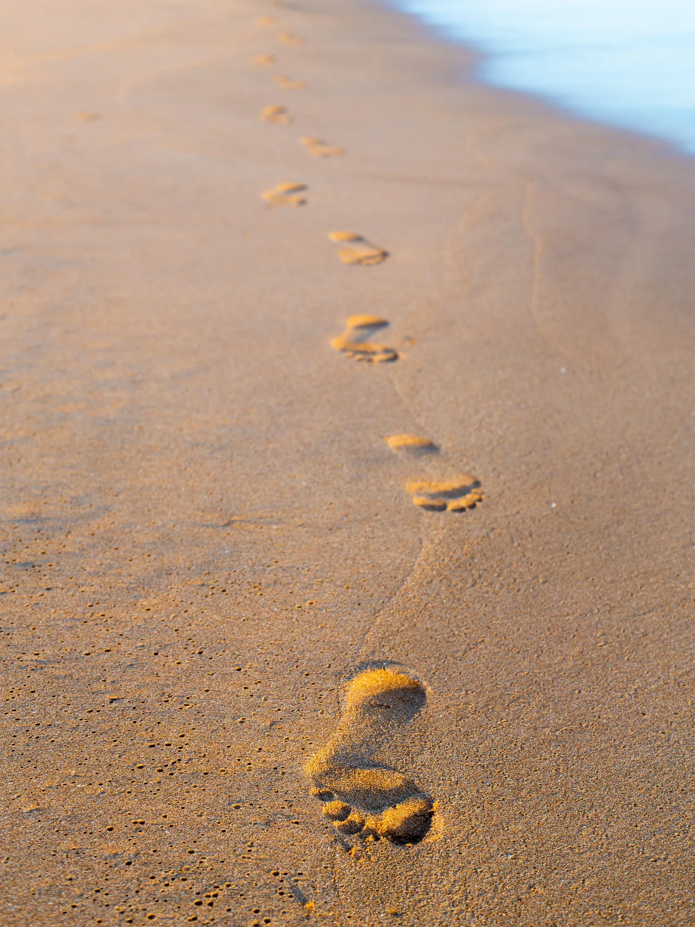 Traces II, Traces de pas dans le sable vers la mer, cadrage vertical