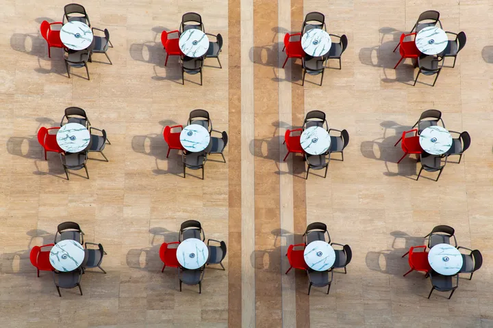 Terrasse vue du ciel, Tables rondes et chaises rouges vues d'en haut en grille