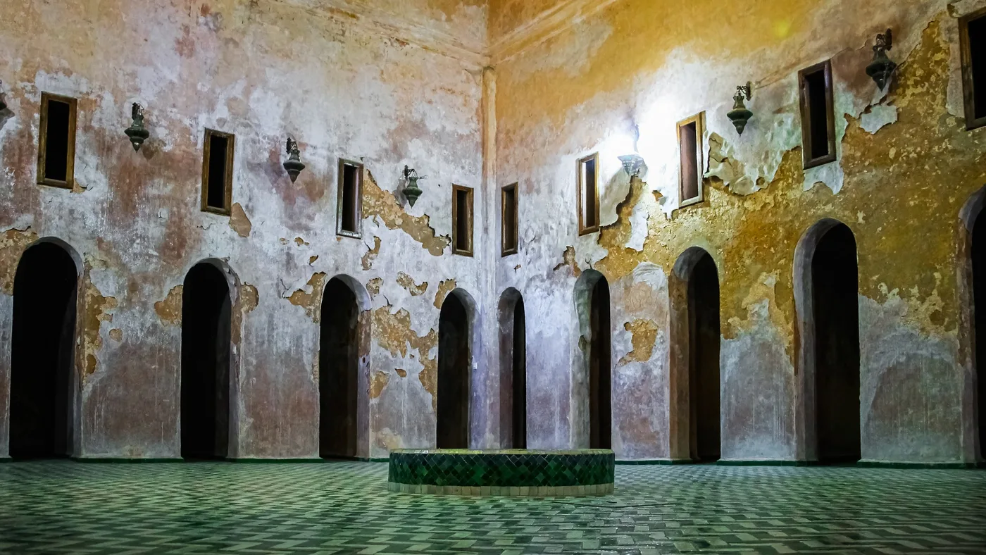 Arcades du temps, Salle ancienne aux murs patinés, arches sombres et sol en zellige vert