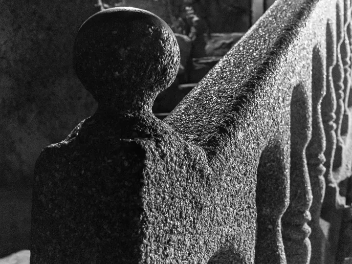 Balustrade en pierre, Gros plan d'une balustrade sculptée à la surface granuleuse, noir et blanc