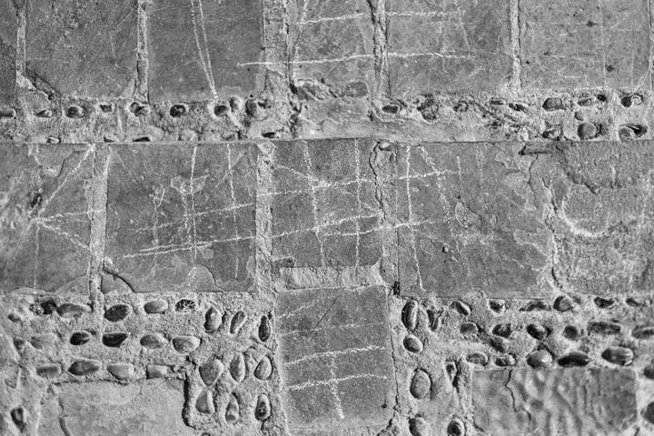 Écritures anciennes, Sol de dalles et de galets avec des traits de craie, vu d'en haut, noir et blanc
