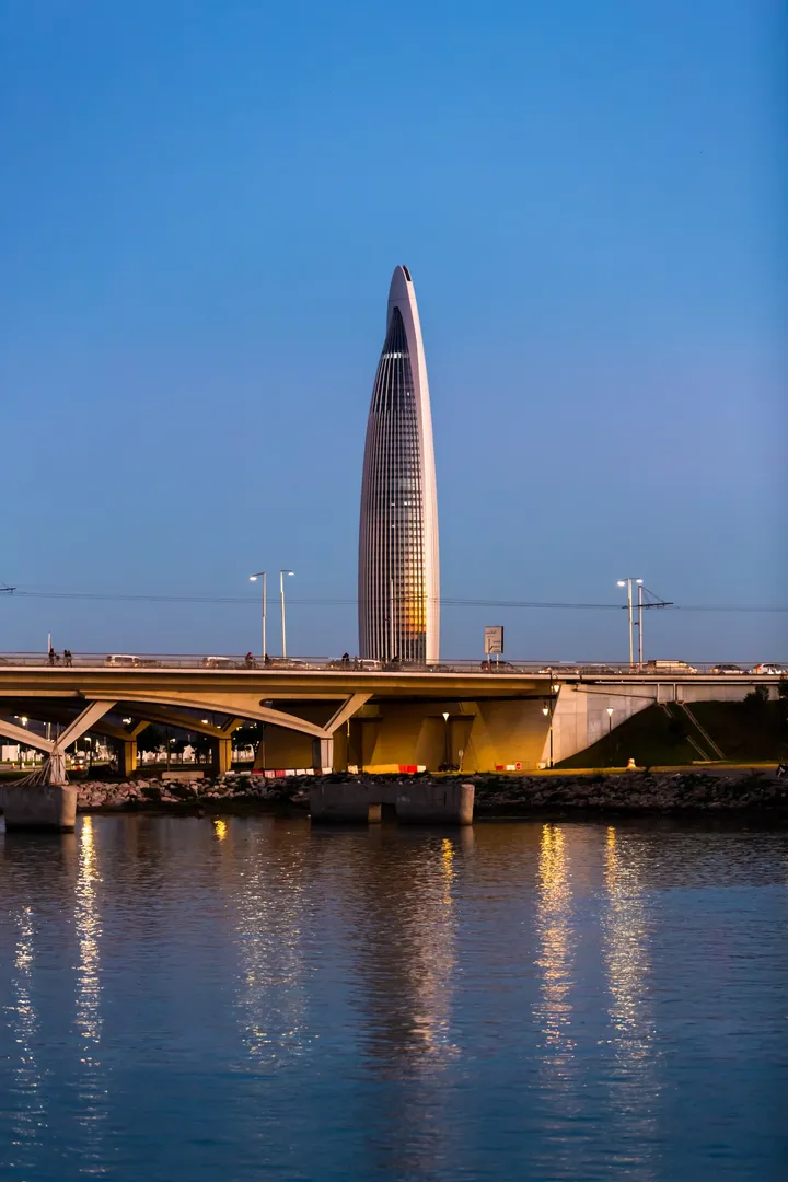 La tour et le pont, Tour moderne derrière un pont, reflets dans l'eau au crépuscule
