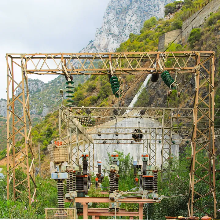 Haute tension, Poste électrique et structures métalliques au pied d'une falaise