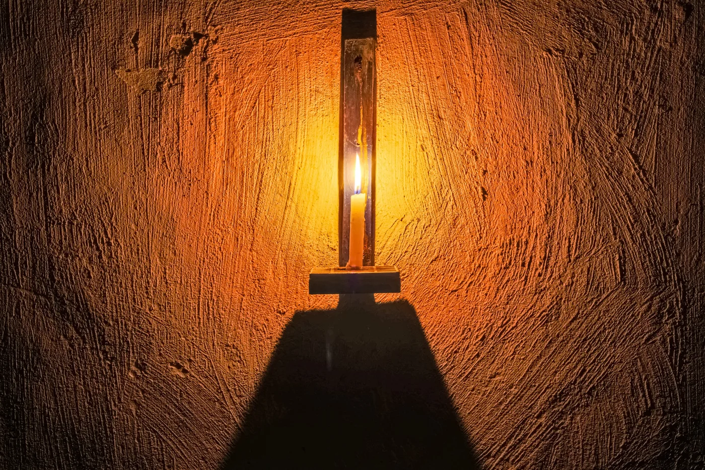 La flamme, Lampe à bougie et son ombre sur un mur ocre texturé