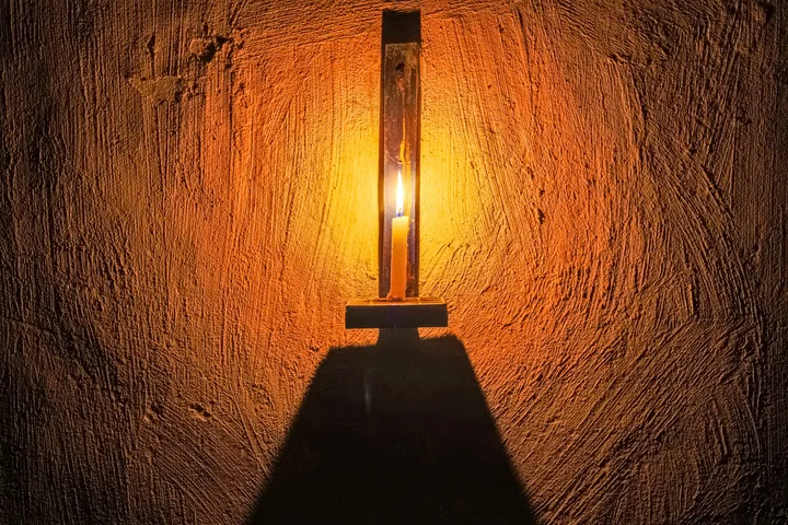 La flamme, Lampe à bougie et son ombre sur un mur ocre texturé