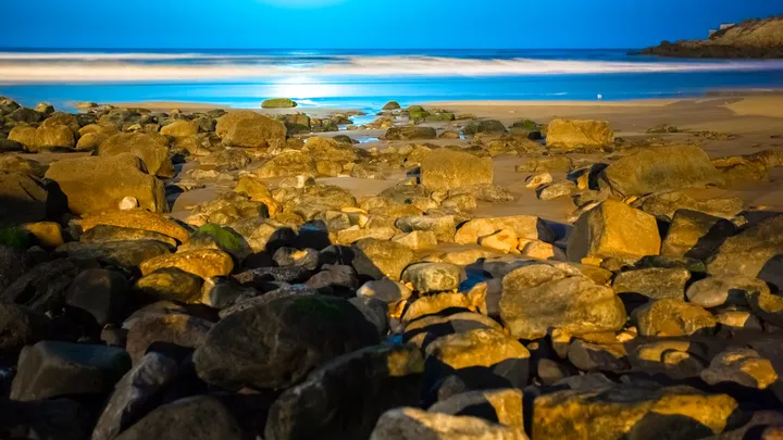 Rochers d'or, Rochers dorés au premier plan et mer bleue adoucie par une pose longue à Imesouane